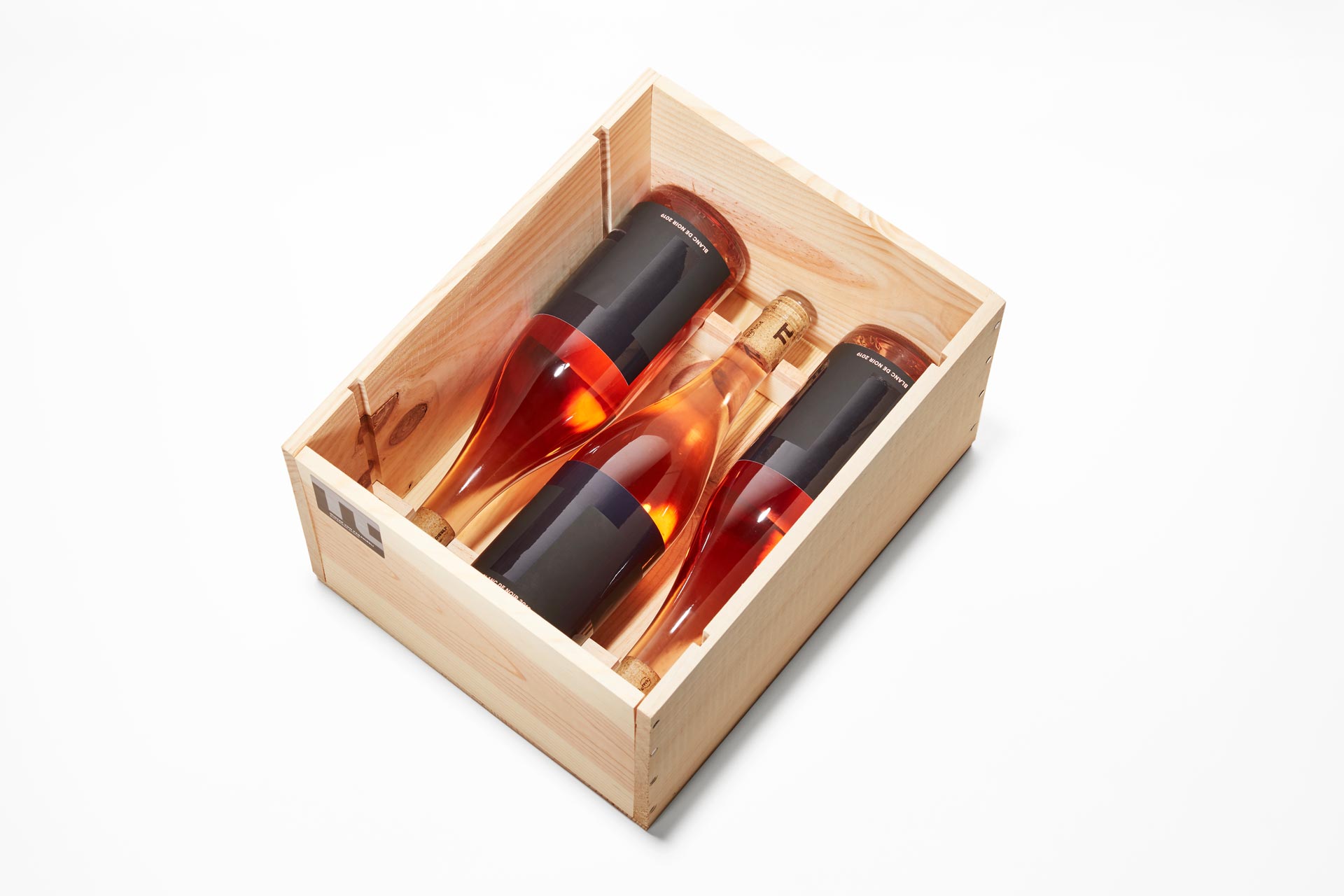 Drei Weinflaschen pi Blanc de Noir 2019 in Weinkiste liegend