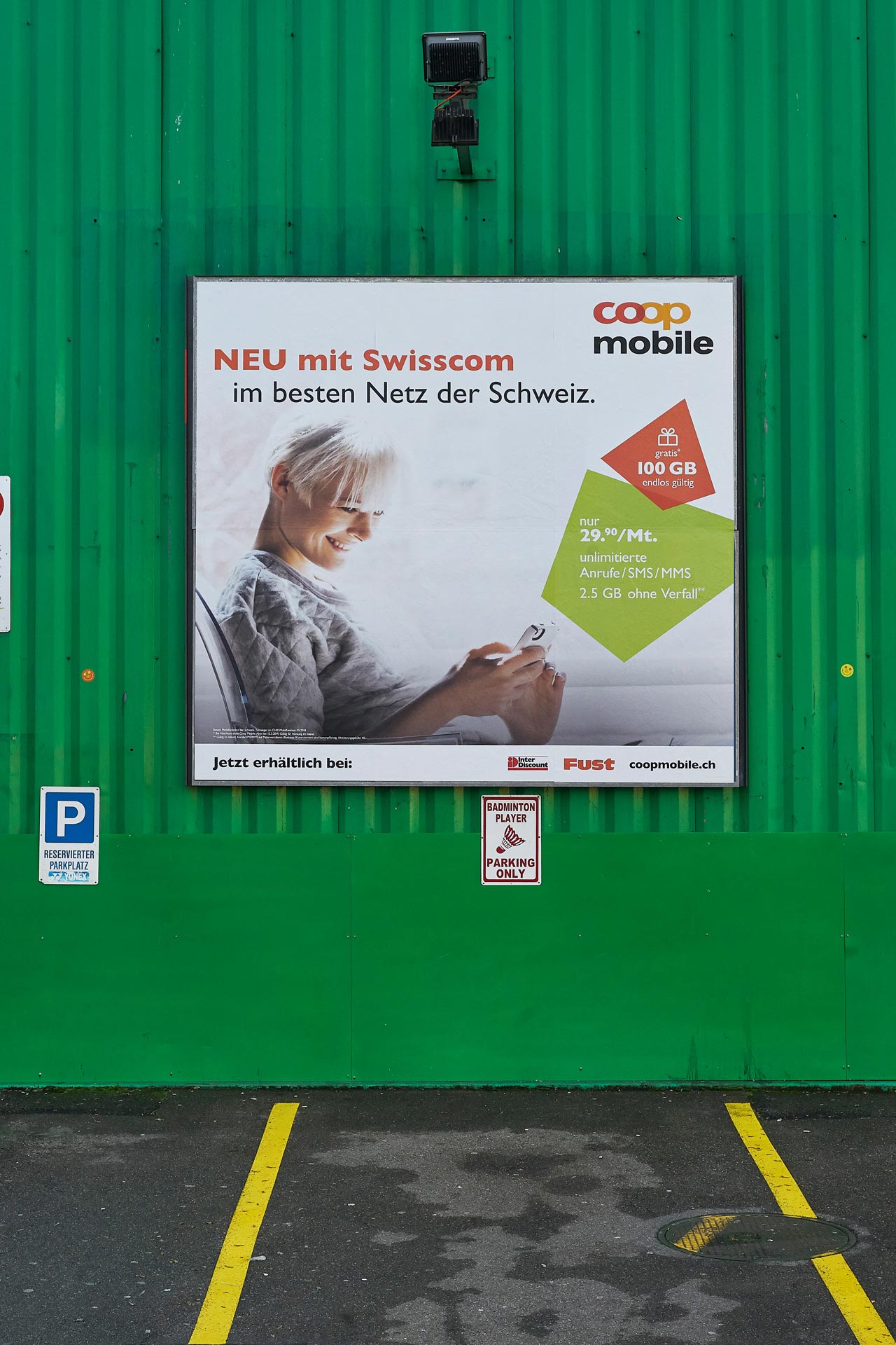 Werbeplakat von Coop Mobile bei öffentlichem Parkplatz